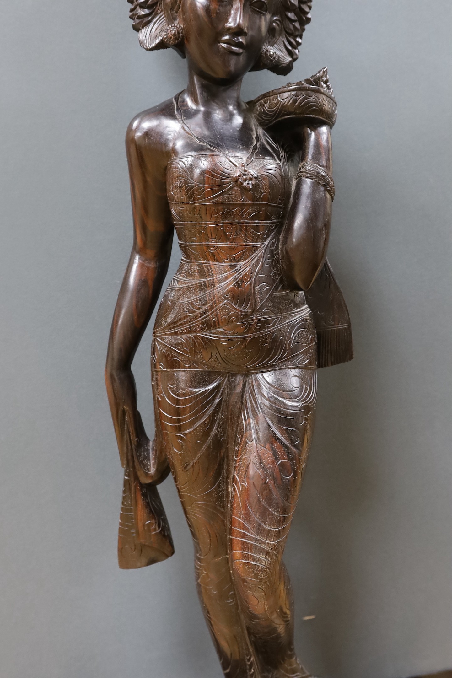 An unusually large and well-carved Balinese ebony figure of a standing young girl, early/mid 20th century. From a Bournemouth estate, 105cm high